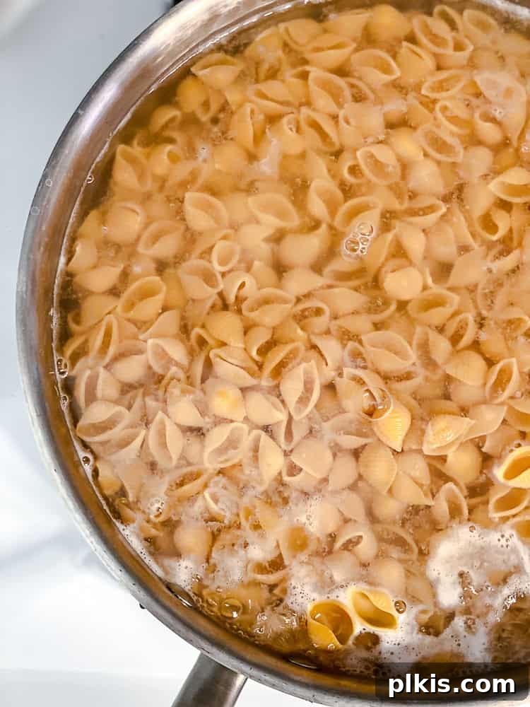 Ultimate Vegan Mac Bake 4 Process shot showing macaroni pasta cooking in a pot of boiling water.