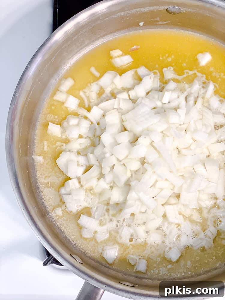 Ultimate Vegan Mac Bake 6 Process shot showing all-purpose flour being whisked into sautéed onions and melted vegan butter to form a roux.