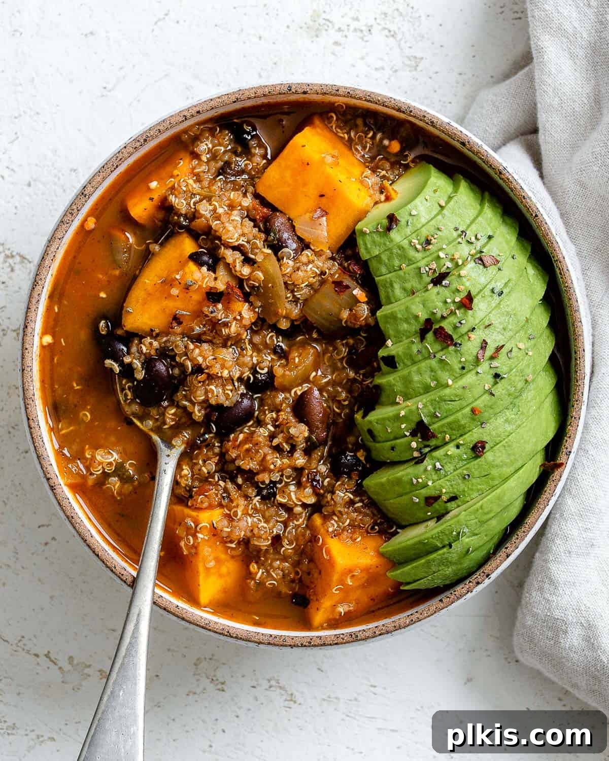 Hearty Sweet Potato Quinoa Chili 2 A vibrant bowl of completed Sweet Potato Quinoa Chili, garnished with fresh cilantro and a dollop of vegan sour cream, ready to be enjoyed.