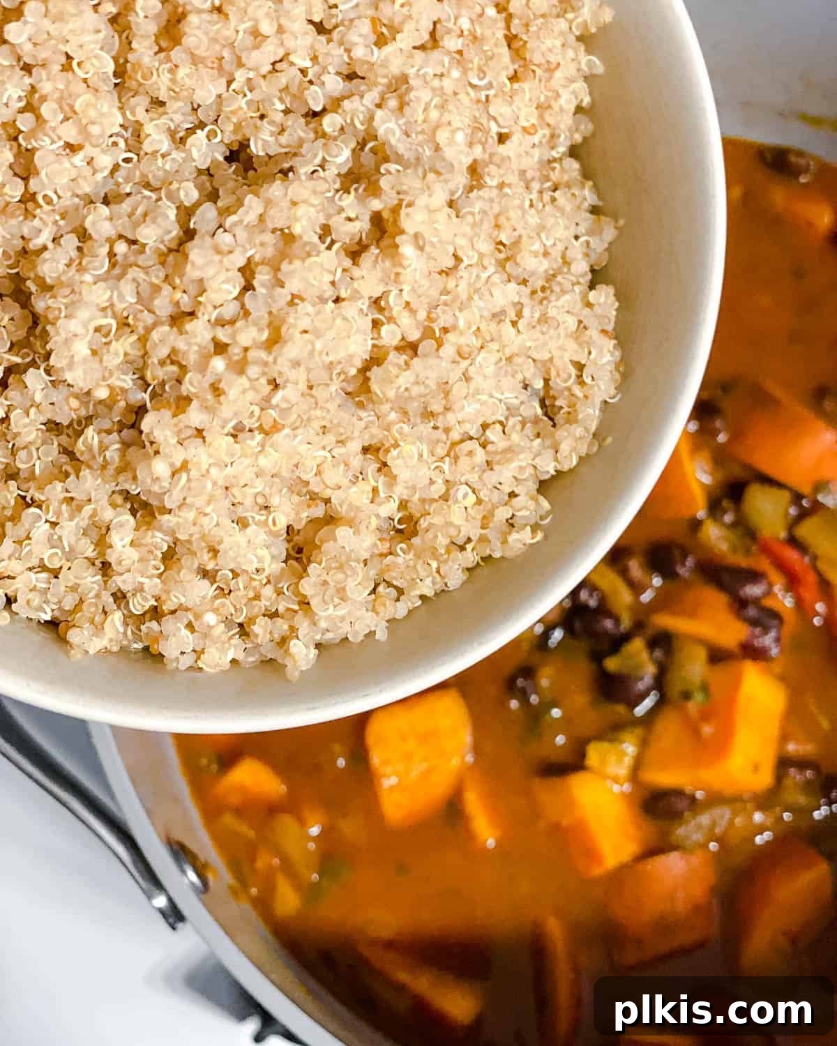 Hearty Sweet Potato Quinoa Chili 8 Process shot demonstrating cooked quinoa being stirred into the thickened sweet potato and black bean chili, completing the hearty meal.