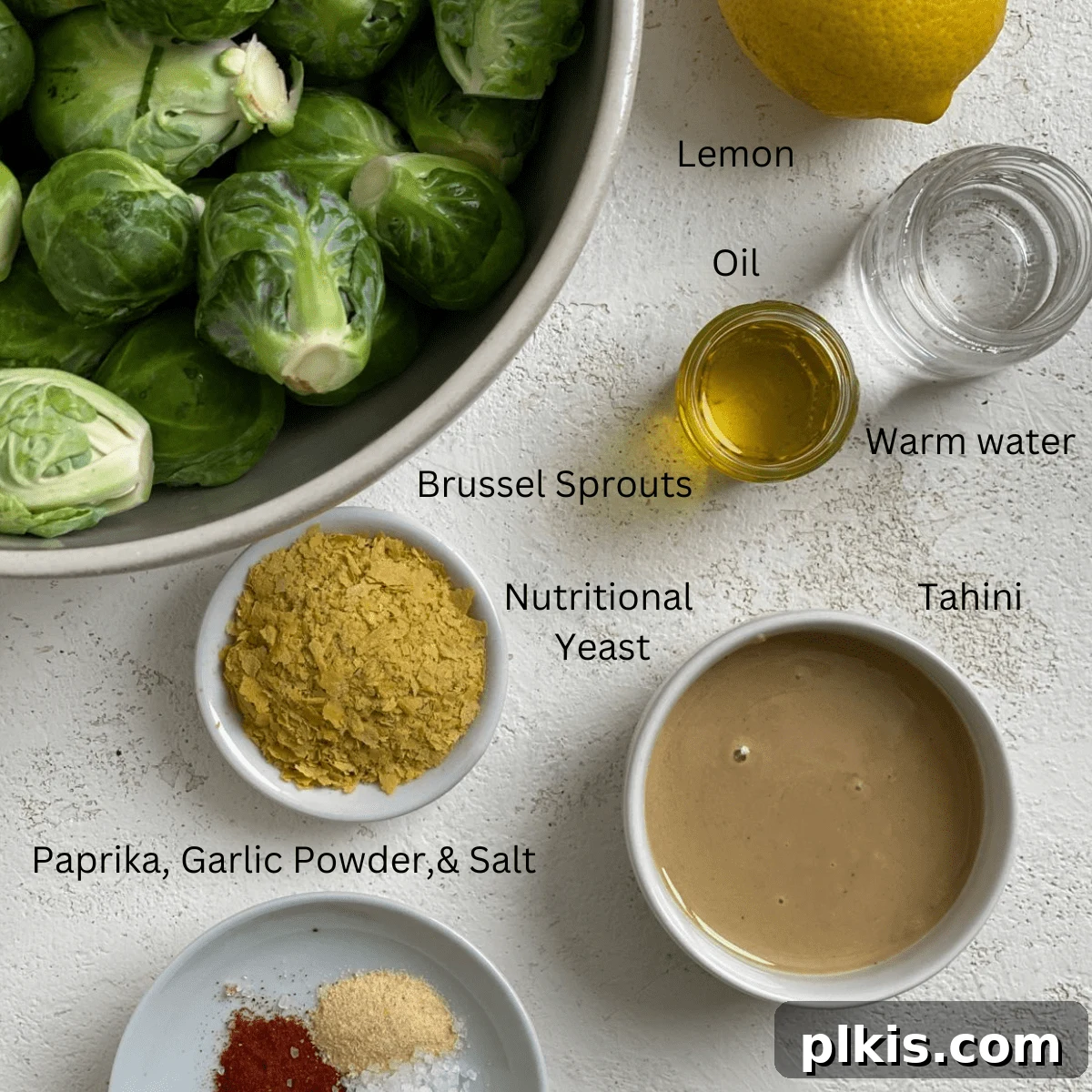 Effortless Vegan Brussels Sprouts Delight 3 Fresh ingredients for Easy Vegan Brussels Sprouts, including raw sprouts, tahini, nutritional yeast, and spices, neatly arranged on a white surface
