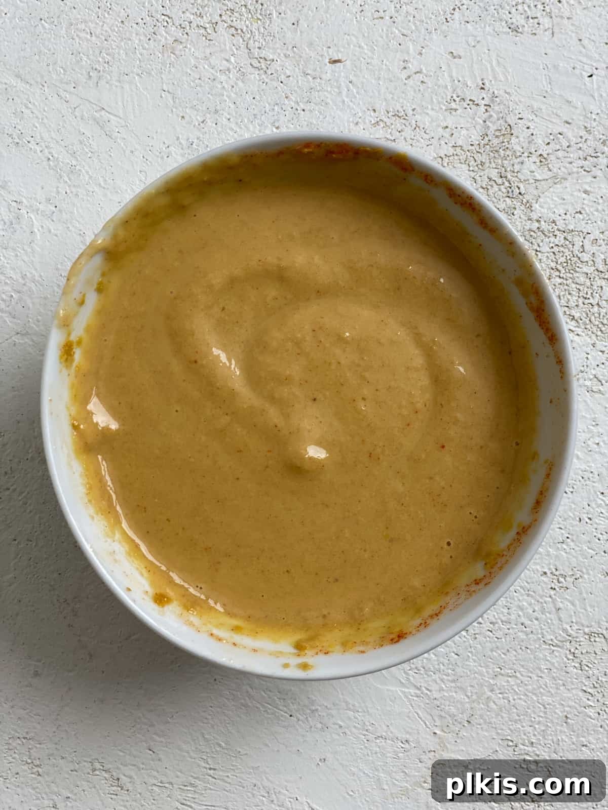 Effortless Vegan Brussels Sprouts Delight 7 The fully mixed, creamy tahini sauce in a white bowl, ready for coating the Brussels sprouts