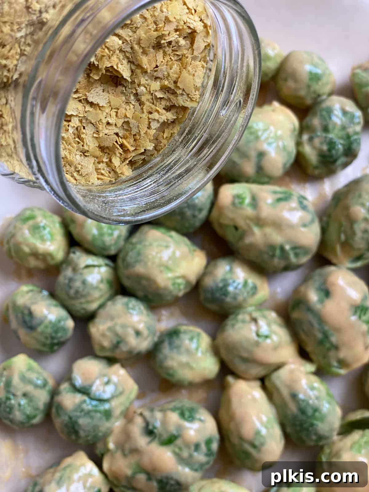 Effortless Vegan Brussels Sprouts Delight 10 Sprinkling extra nutritional yeast over the Brussels sprouts on the baking sheet