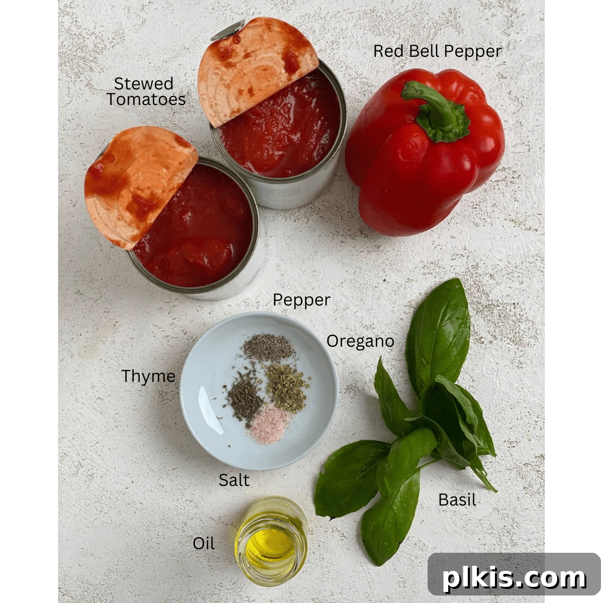 Pantry-Friendly Vegan Tomato Soup 3 All the fresh and canned ingredients for the Tasty Tomato Soup, neatly arranged on a white surface.