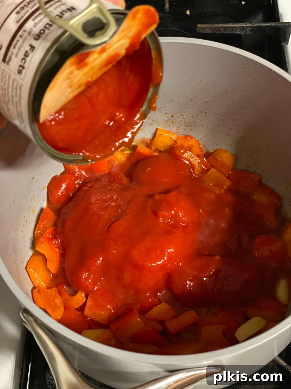 Pantry-Friendly Vegan Tomato Soup 5 Process shot of adding canned tomatoes to the pan.