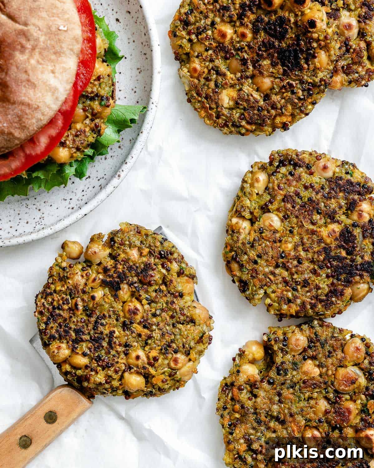 Golden Quinoa Chickpea Fritters 2 completed Quinoa Chickpea Patties on a white surface alongside a burger
