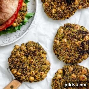 Golden Quinoa Chickpea Fritters 13 completed Quinoa Chickpea Patties on a white surface alongside a burger
