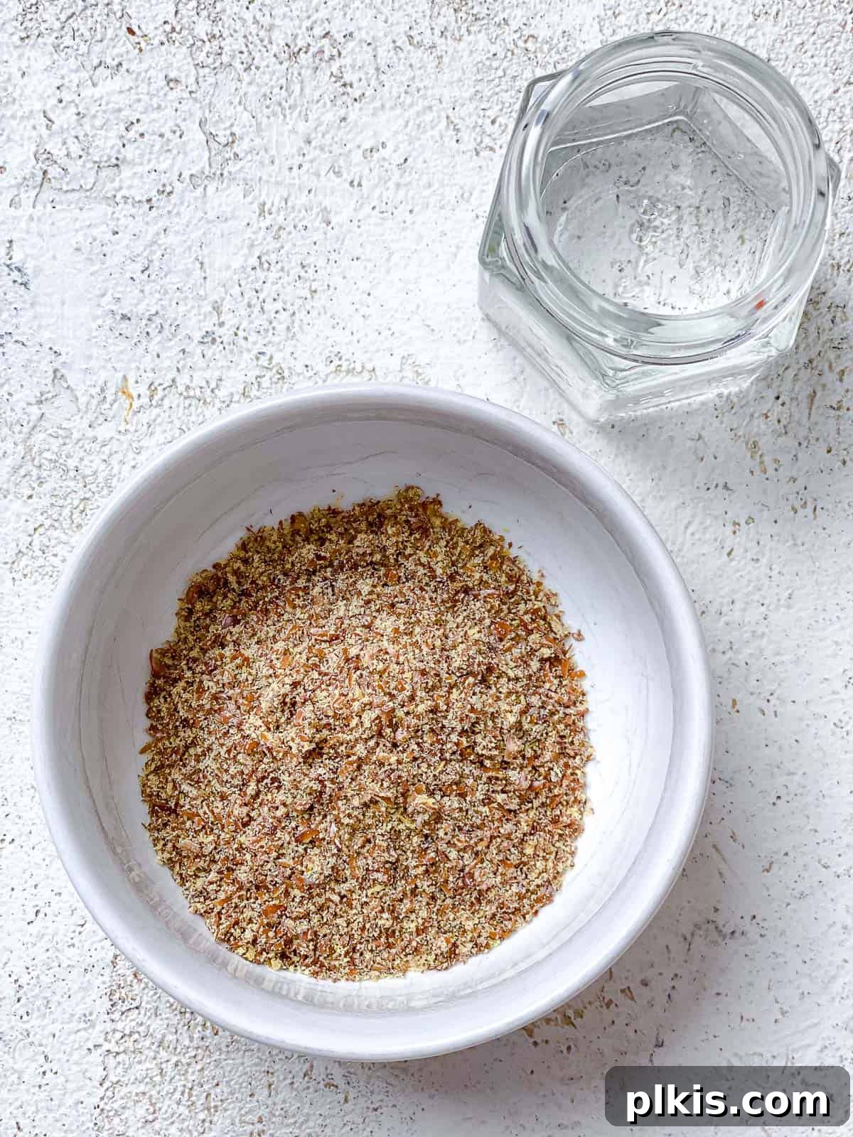Golden Quinoa Chickpea Fritters 4 bowl of flaxseed and water measured out on a white surface