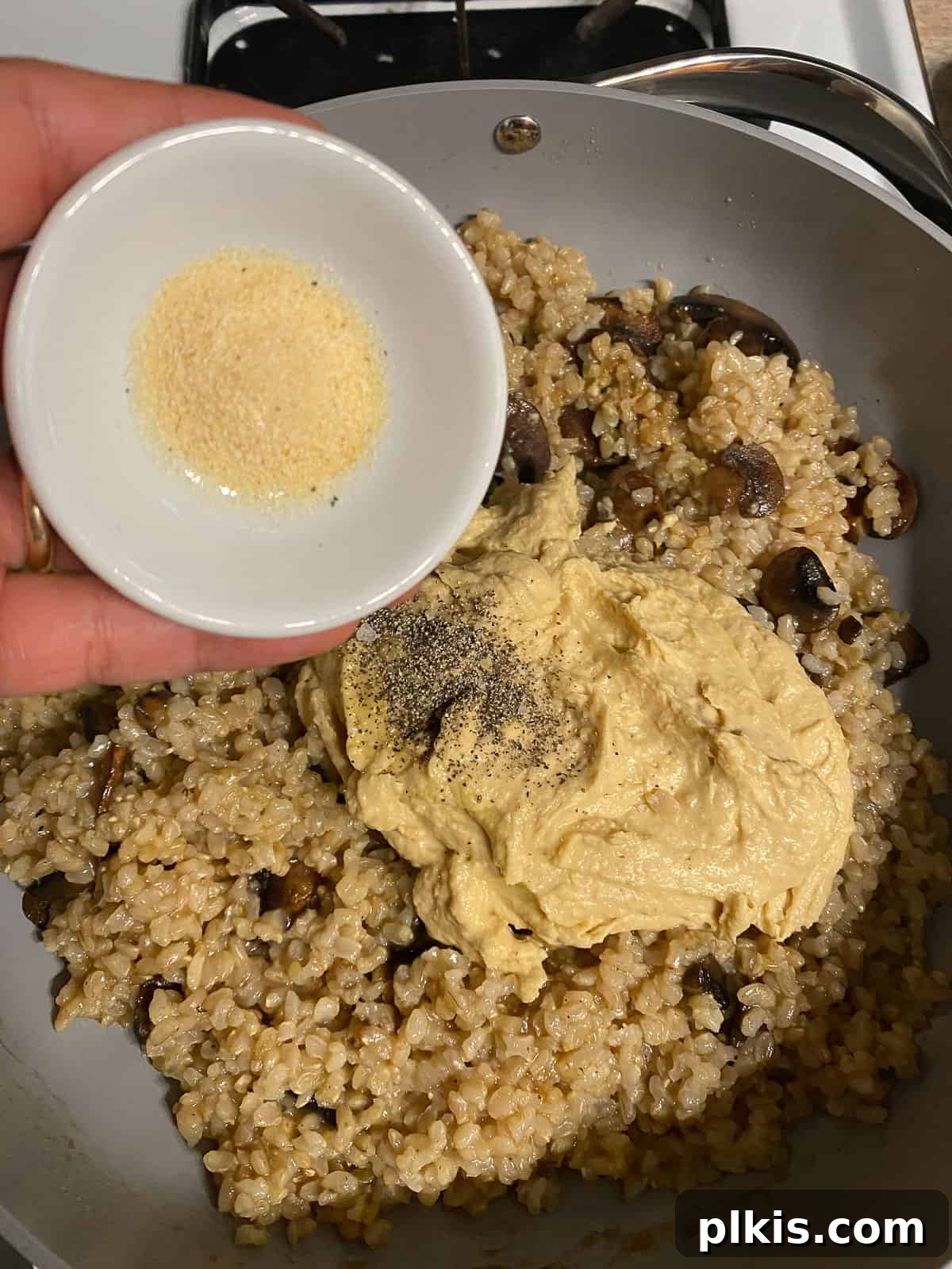 Velvety Brown Rice Risotto 12 Process shot of stirring all ingredients together in the pan to achieve a creamy consistency.