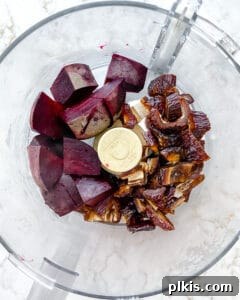 Detailed process of adding all ingredients into a food processor to create the beet energy ball mixture.