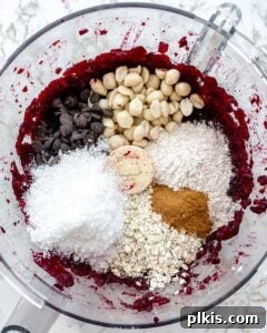 Vibrant Beet Power Bites 6 The process of blending all ingredients into a thick, vibrant dough within a food processor for beet energy balls.