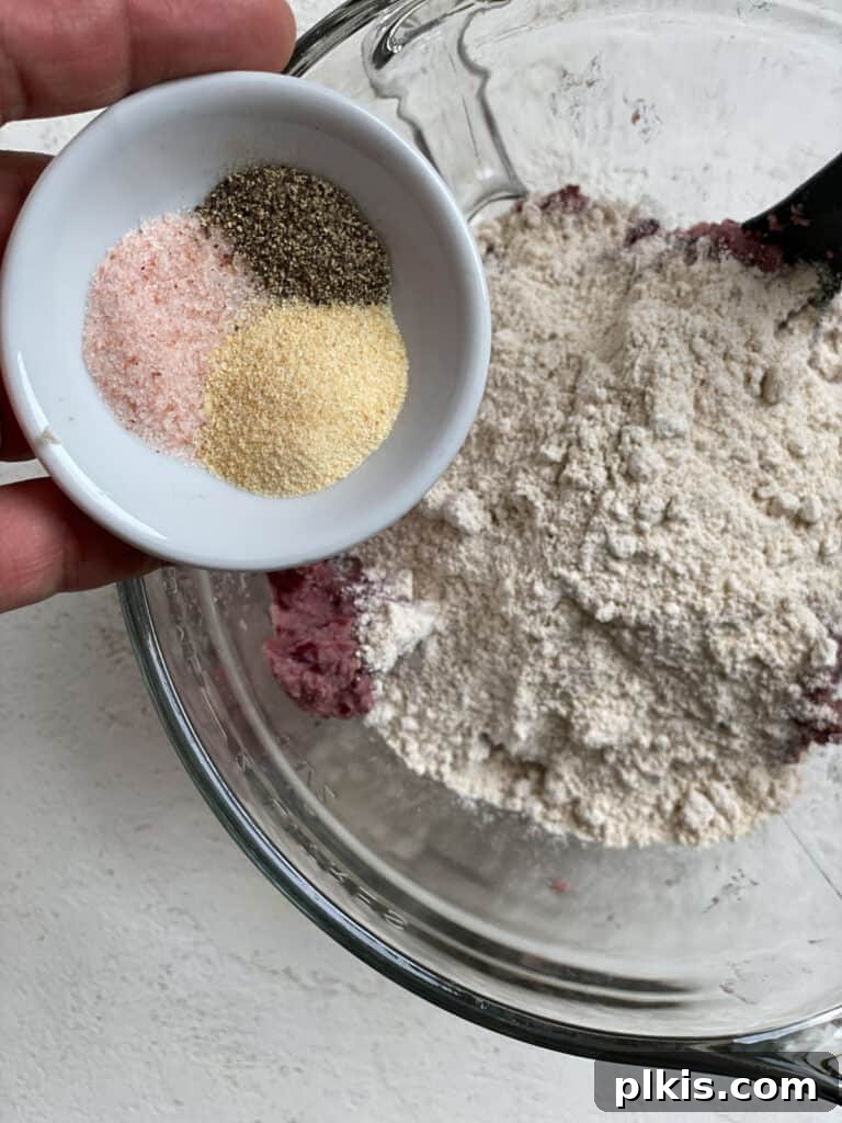 Quick-Fix 4-Ingredient Vegan Burgers 7 Process shot of adding seasonings, including salt, pepper, and garlic powder, to the burger mixture