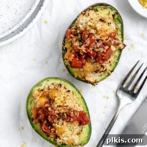 Completed Healthy Stuffed Avocados against a white surface, ready to be served and enjoyed.