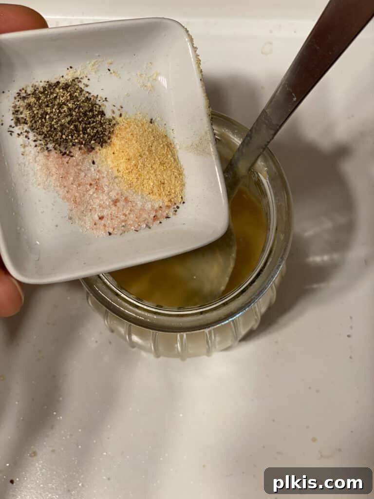 Fresh Lemon Herb Lentil Chickpea Salad 12 Process shot of adding spices to the dressing mixture.