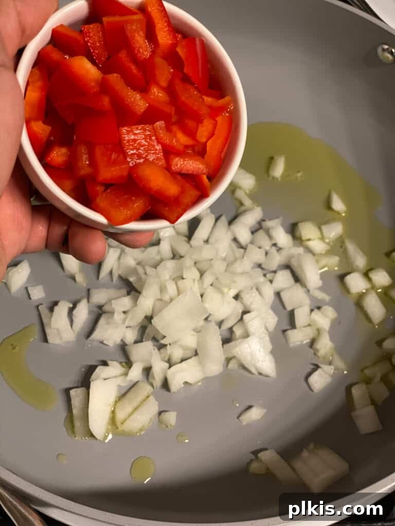 Fresh Lemon Herb Lentil Chickpea Salad 6 Process shot of adding diced bell peppers to the pan with onions.