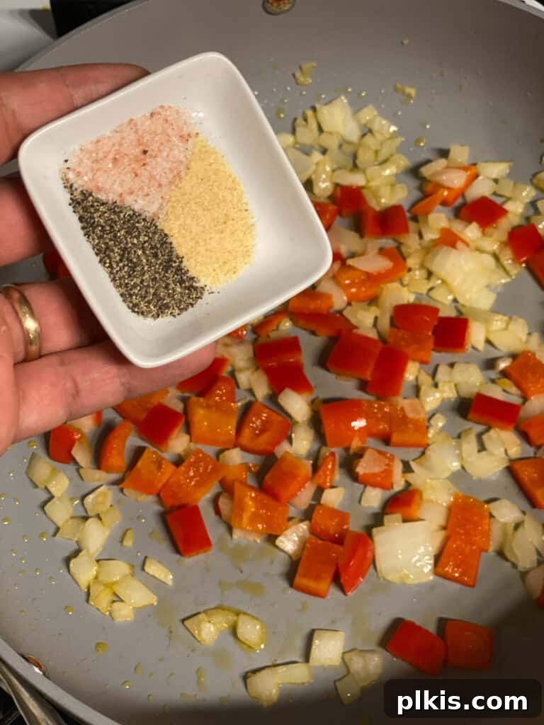 Fresh Lemon Herb Lentil Chickpea Salad 7 Process shot of seasoning the cooking vegetables with spices.