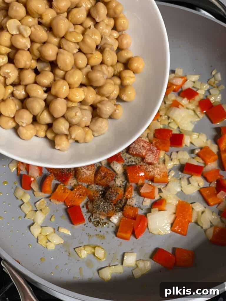 Fresh Lemon Herb Lentil Chickpea Salad 8 Process shot of adding chickpeas to the pan with sautéed vegetables.