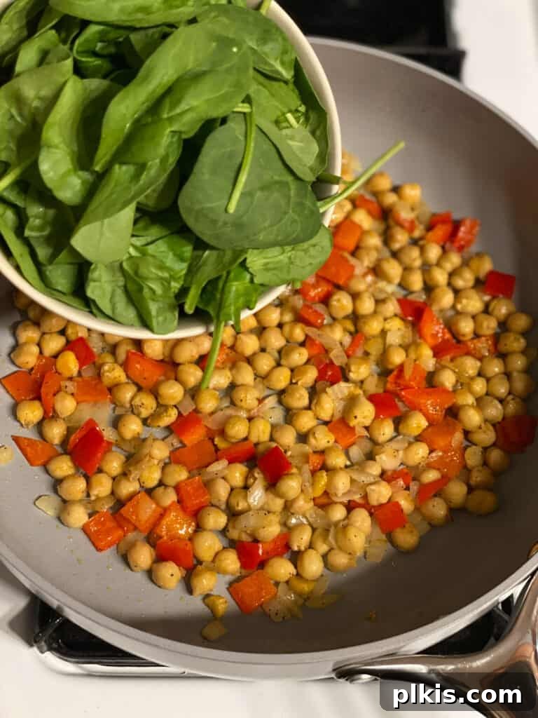 Fresh Lemon Herb Lentil Chickpea Salad 9 Process shot of adding spinach to the pan, just before covering.