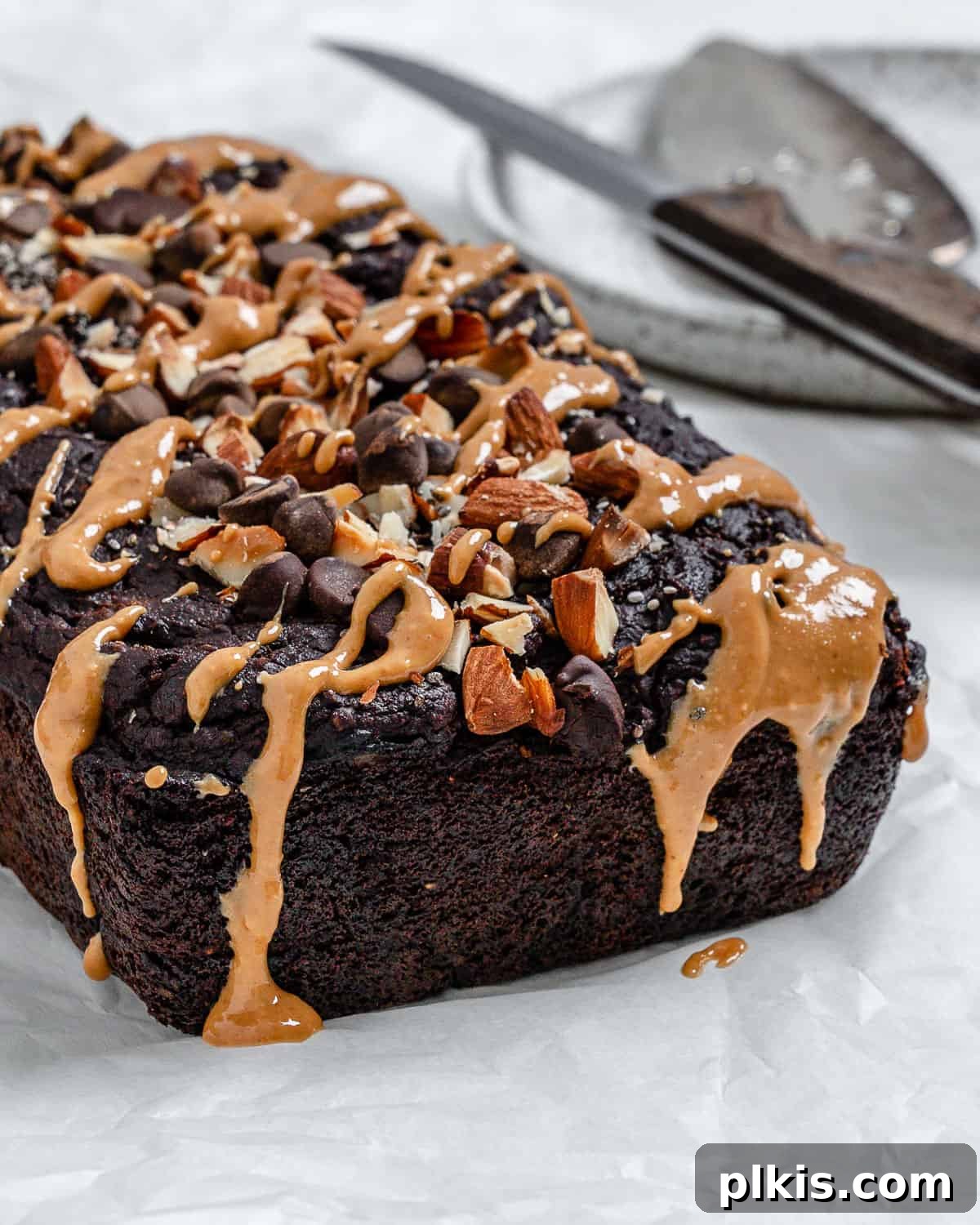 Decadent Sweet Potato Chocolate Cake 13 A freshly baked and cooled Sweet Potato Chocolate Cake resting on a white surface, ready to be sliced