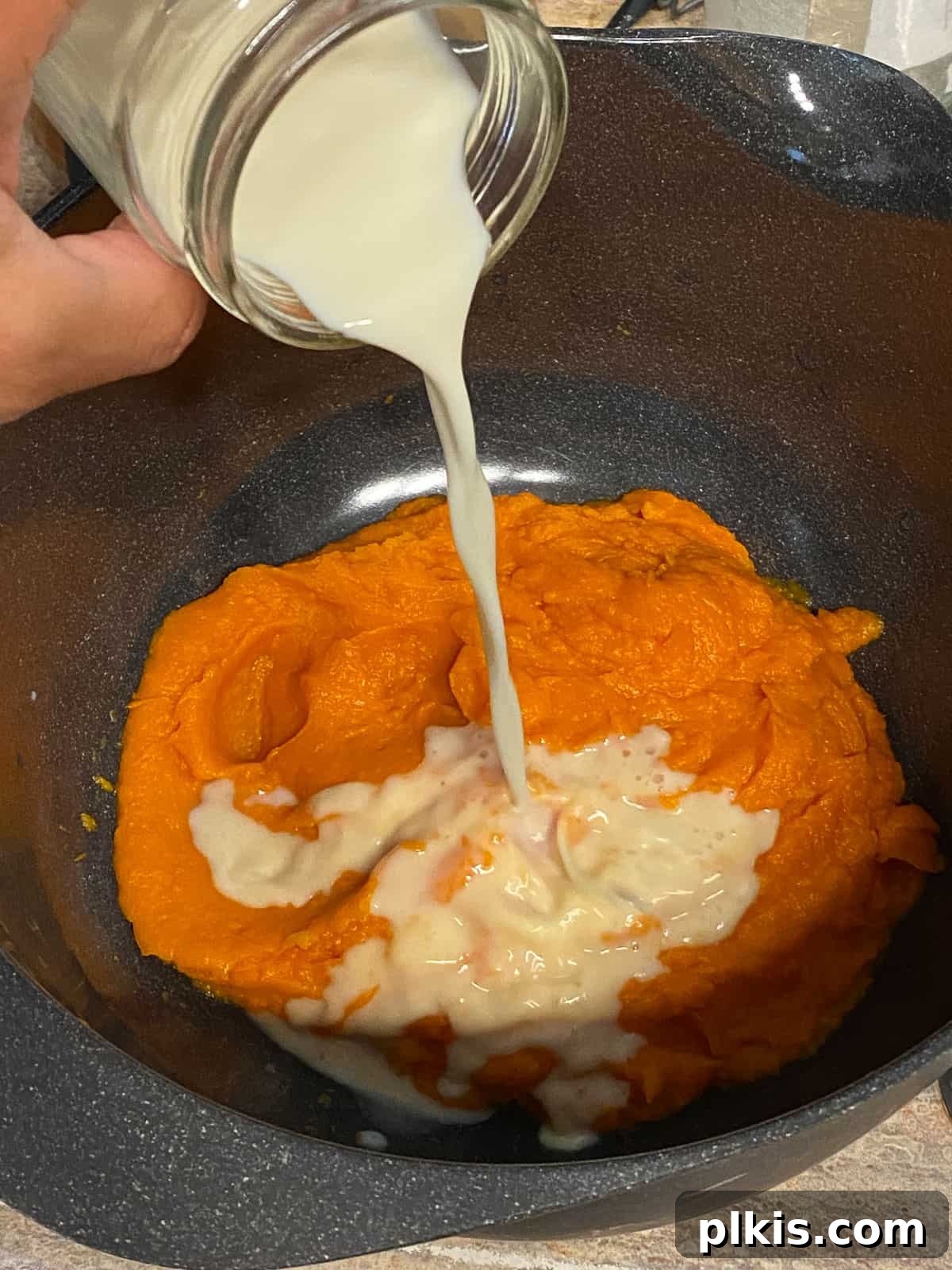 Decadent Sweet Potato Chocolate Cake 5 Process shot of pouring plant-based milk into the sweet potato mixture in a mixing bowl