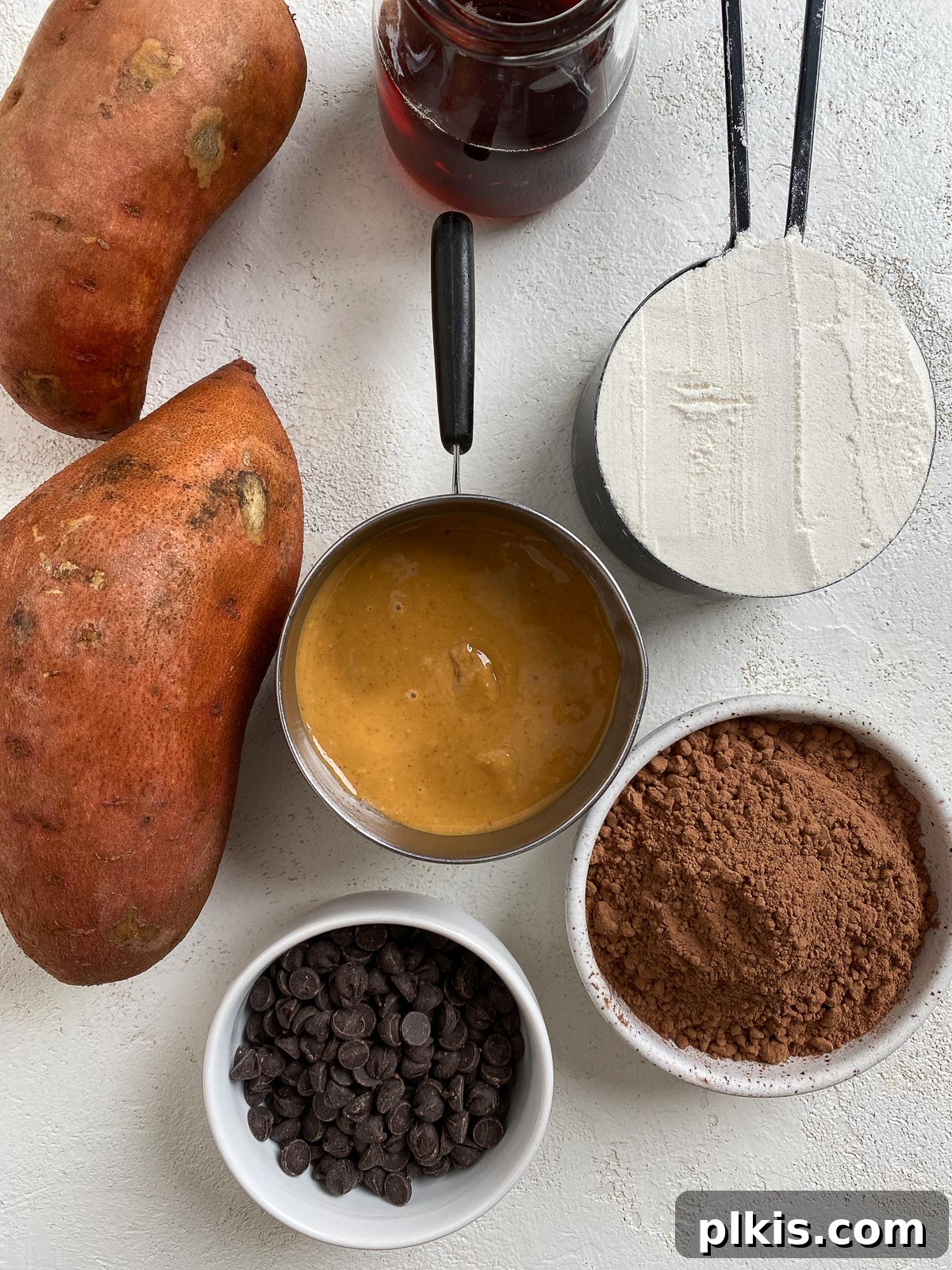 Decadent Vegan Sweet Potato Brownies 3 ingredients for Sweet Potato Brownies laid out on a white surface