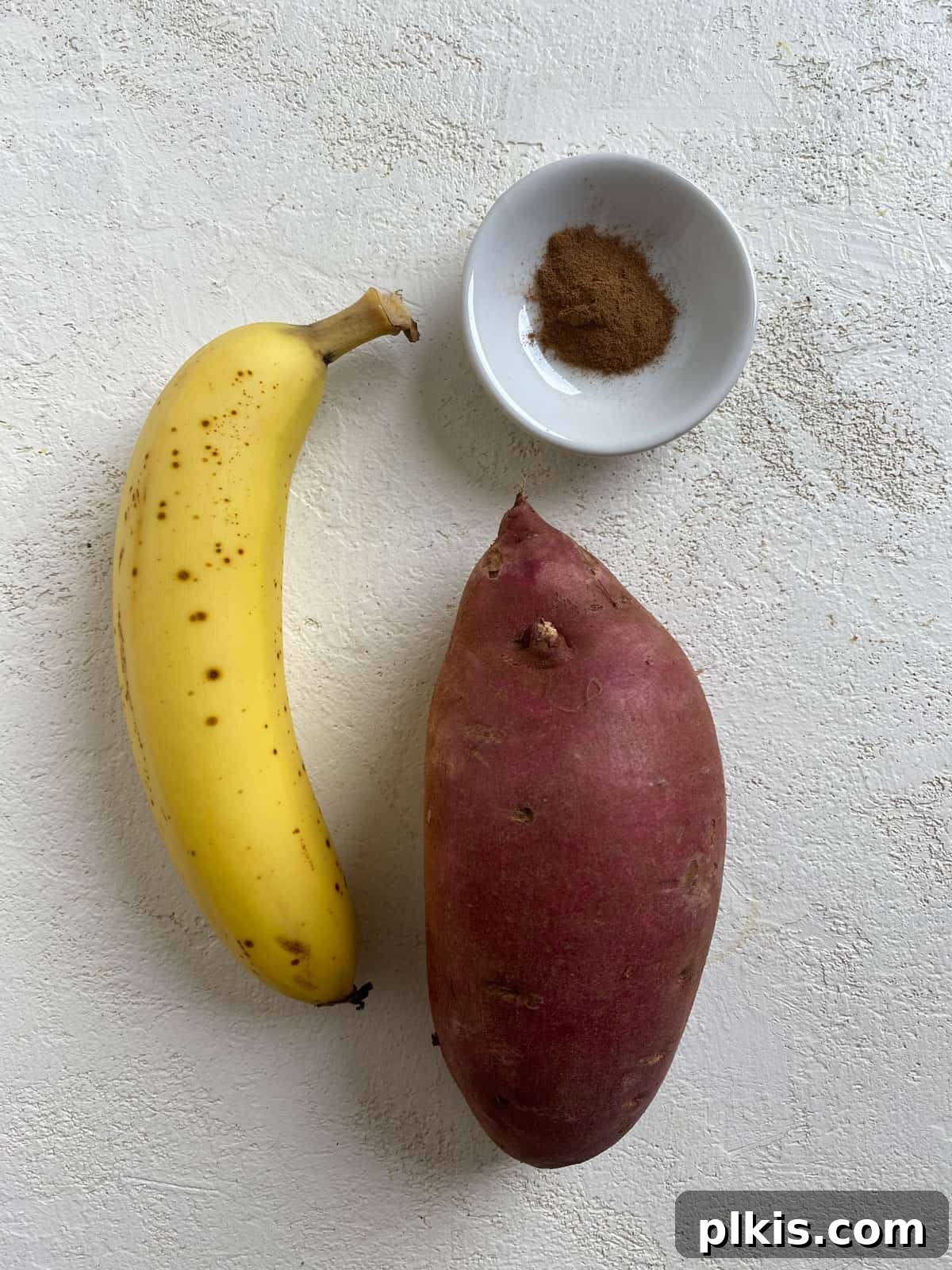 Sweet Potato Toast: Beyond Bread 3 Ingredients for Easy Sweet Potato Toast measured out on a white surface, including sweet potato, banana, and cinnamon.