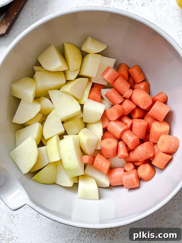Rich Nacho Cheese Sauce 4 process shot showing chopped potatoes and carrots in a bowl, ready for cooking