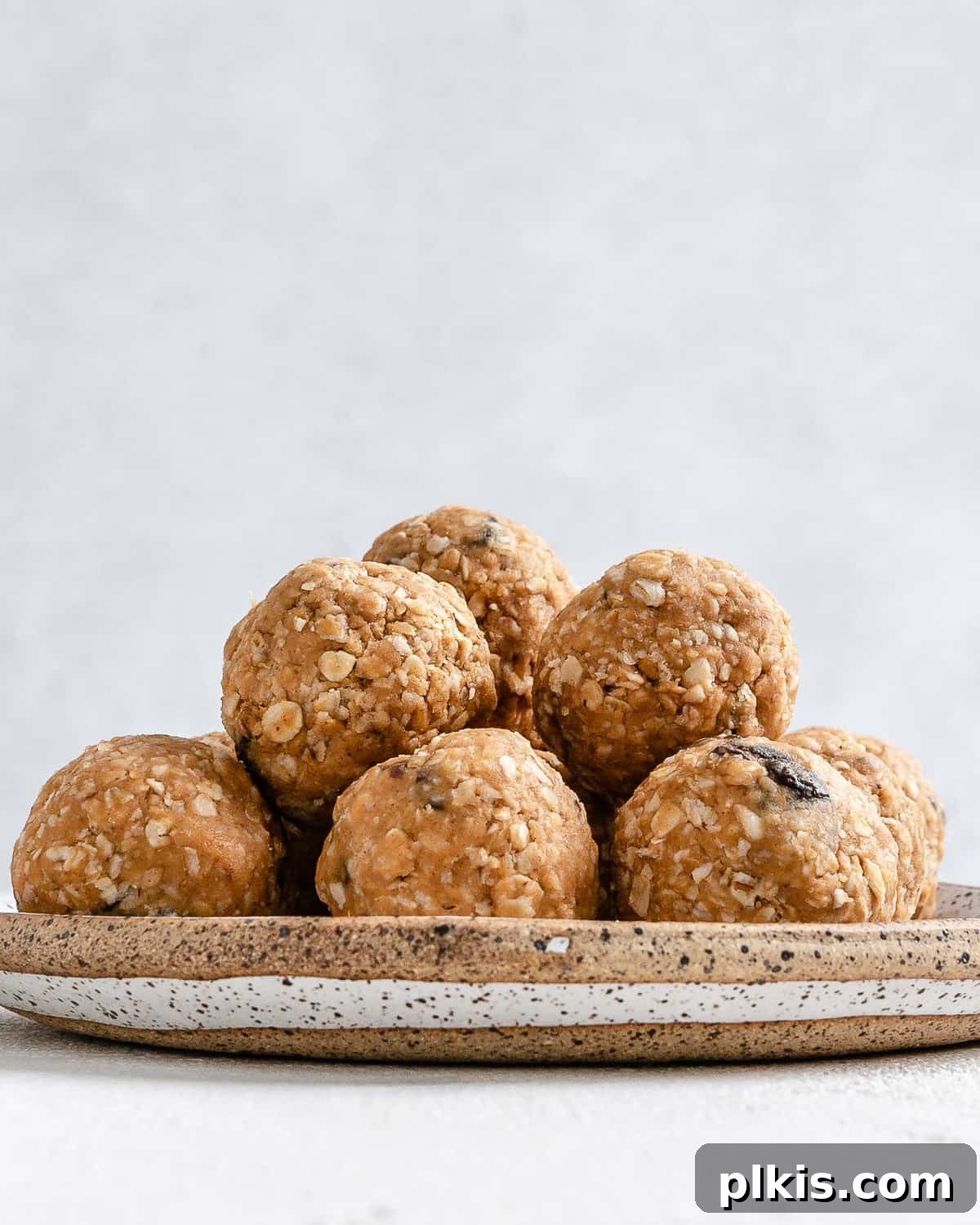 A beautifully presented plate of finished peanut butter oatmeal energy balls, highlighting their appealing texture and snack-ready form, against a light background.
