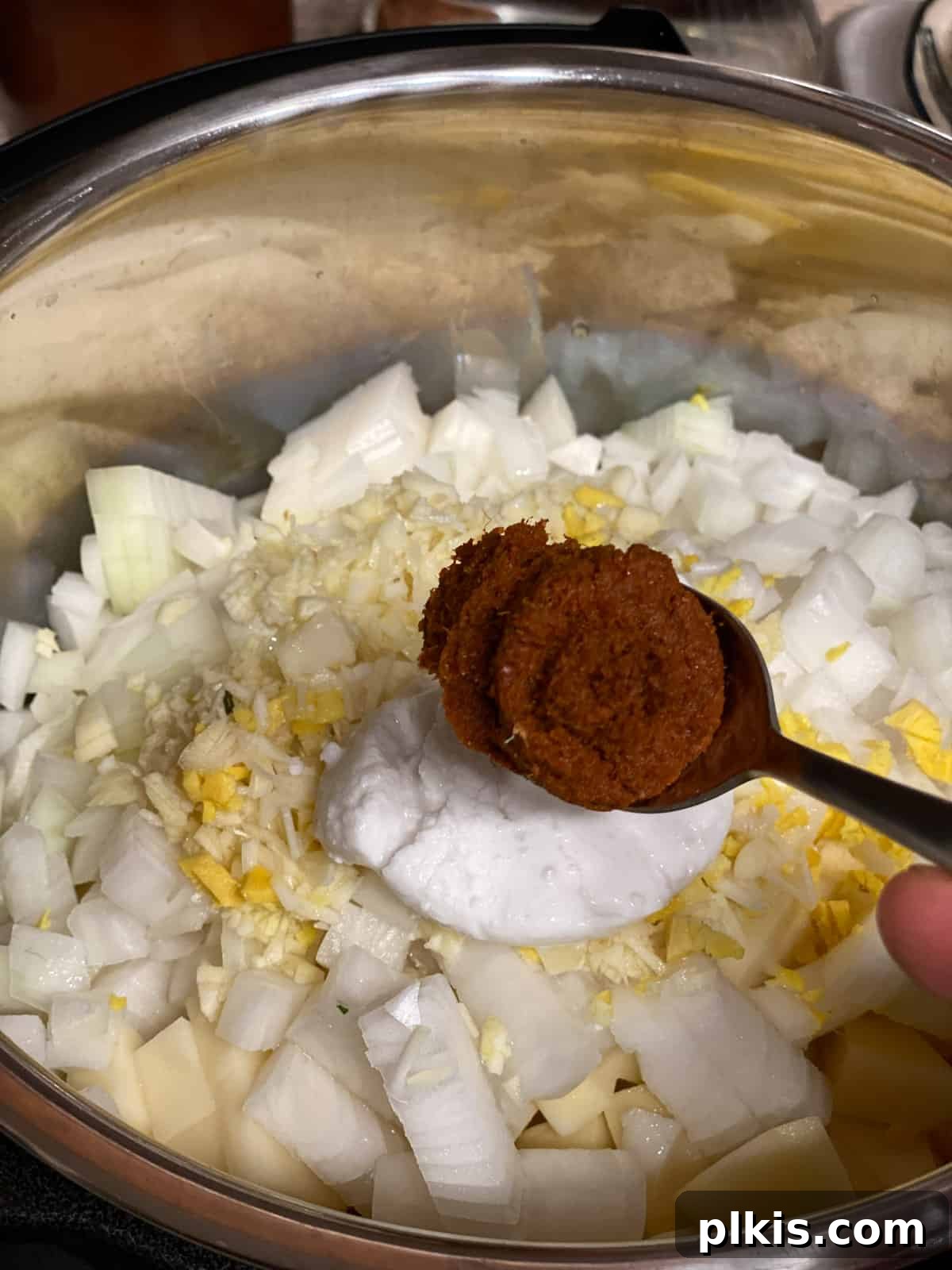 Creamy Red Curry Tofu: Slow Cooker or Stove Top 13 Red curry paste being scooped into the pan, the key flavor component for the Slow Cooker Red Thai Curry.