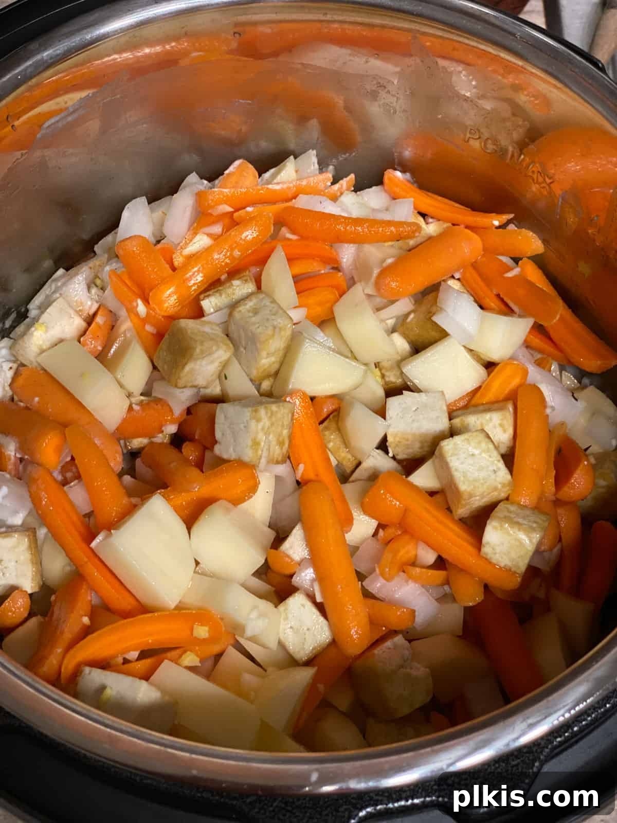 Creamy Red Curry Tofu: Slow Cooker or Stove Top 14 All the ingredients for the Slow Cooker Red Thai Curry being mixed together thoroughly in the pan, ensuring even distribution of flavors.