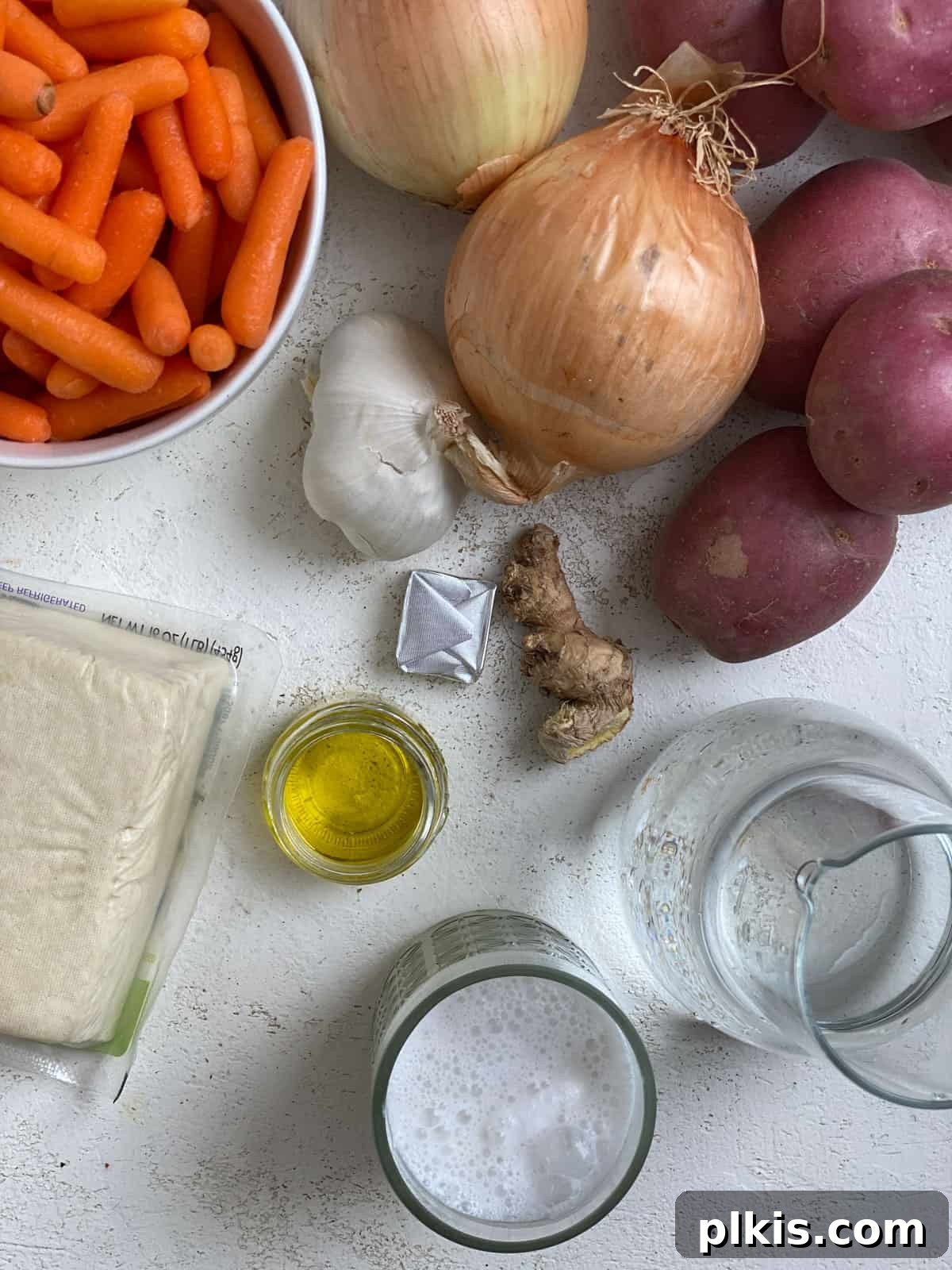Creamy Red Curry Tofu: Slow Cooker or Stove Top 3 A perfectly arranged flat lay showcasing all the fresh and pantry ingredients needed for Slow Cooker Red Thai Curry with Tofu, measured out on a pristine white surface, ready for cooking.