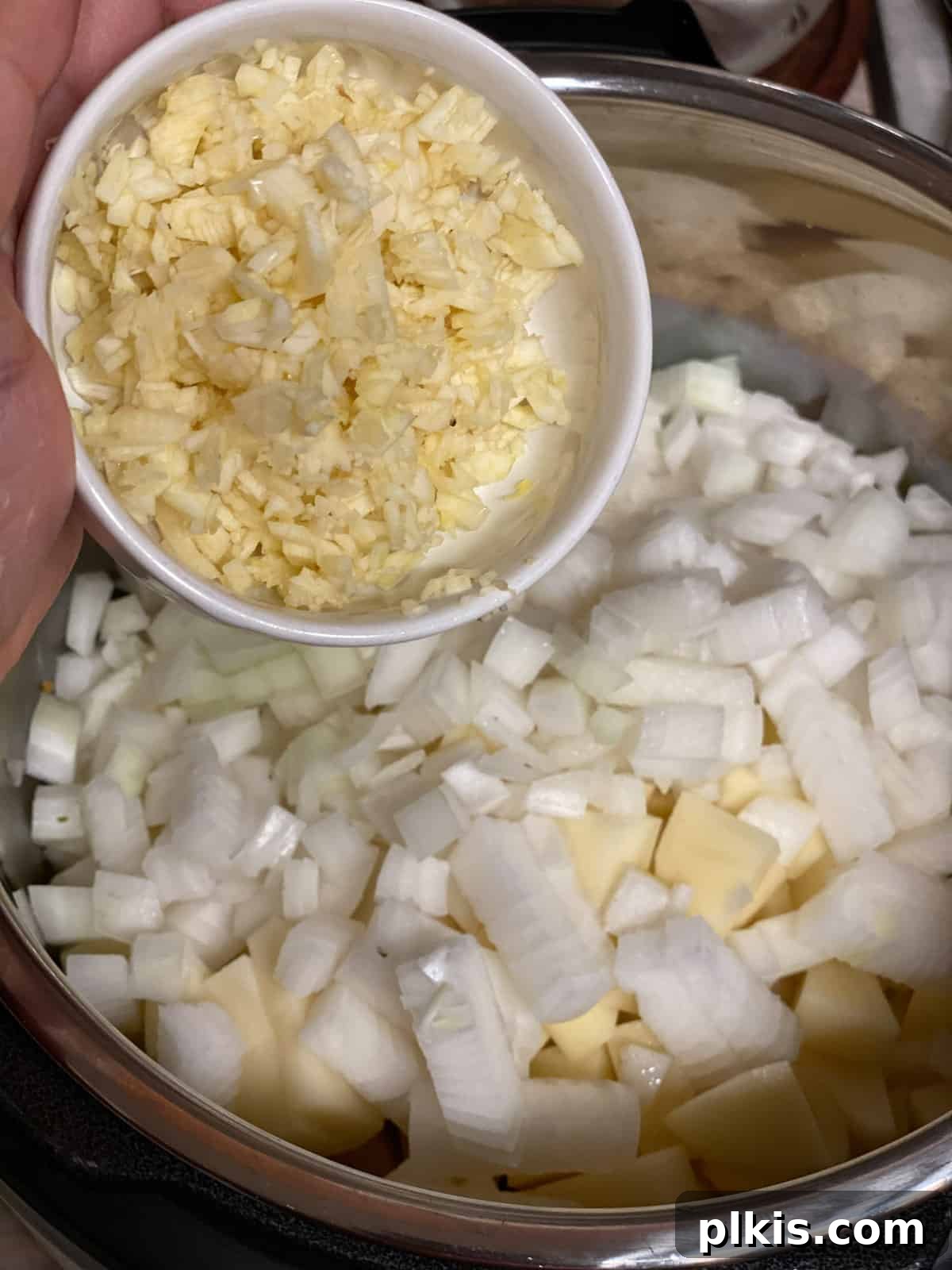 Creamy Red Curry Tofu: Slow Cooker or Stove Top 9 Minced garlic being added to the pan, an essential aromatic for the flavorful Thai curry.
