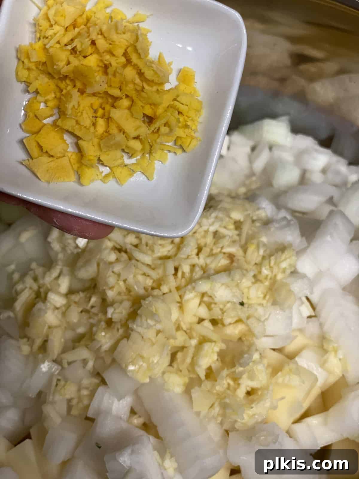 Creamy Red Curry Tofu: Slow Cooker or Stove Top 10 Minced ginger being added to the pan, adding another layer of aromatic spice to the Red Thai Curry.