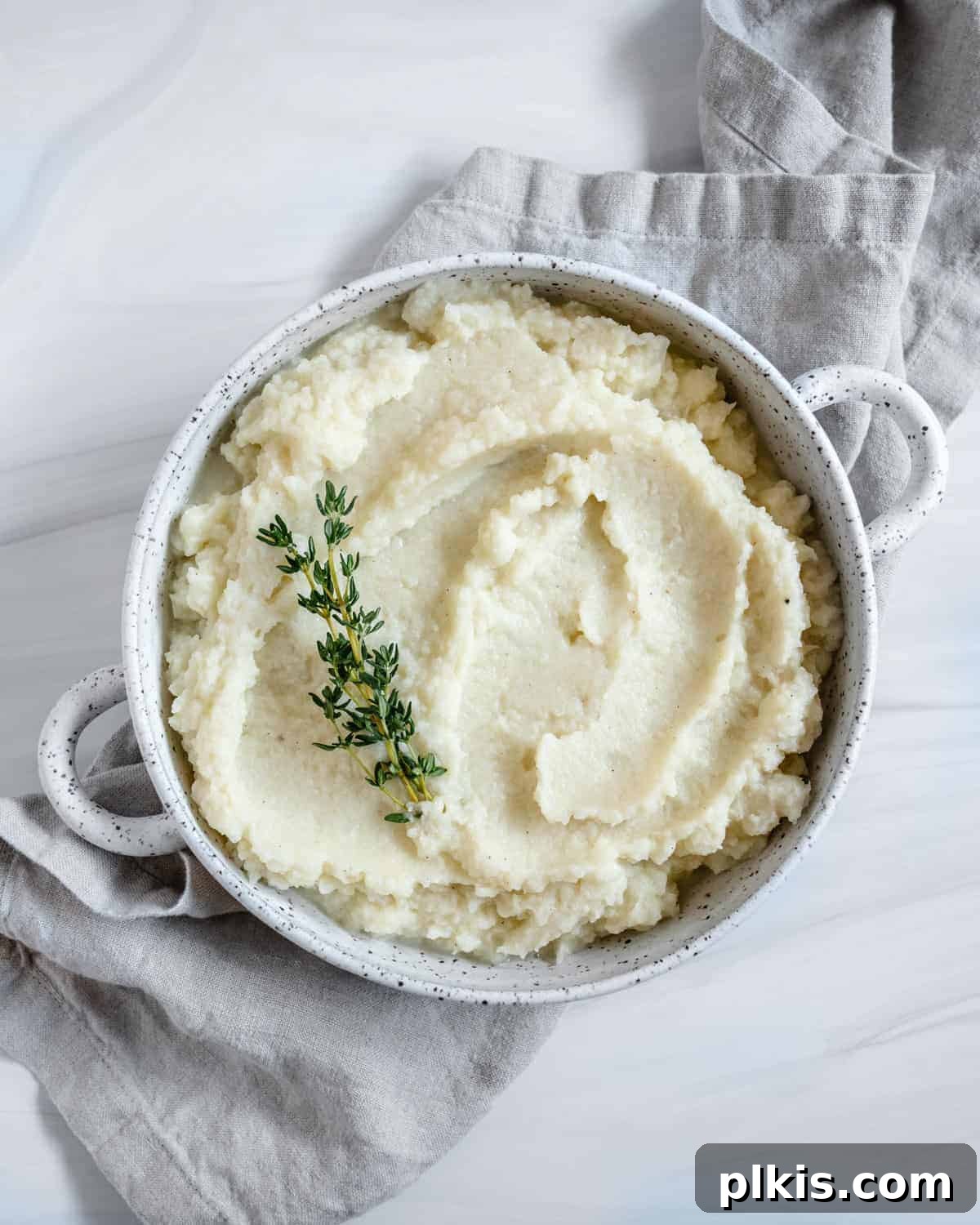 Creamy Vegan Mashed Cauliflower Keto Low Carb 2 completed mashed cauliflower in a white dish against white background
