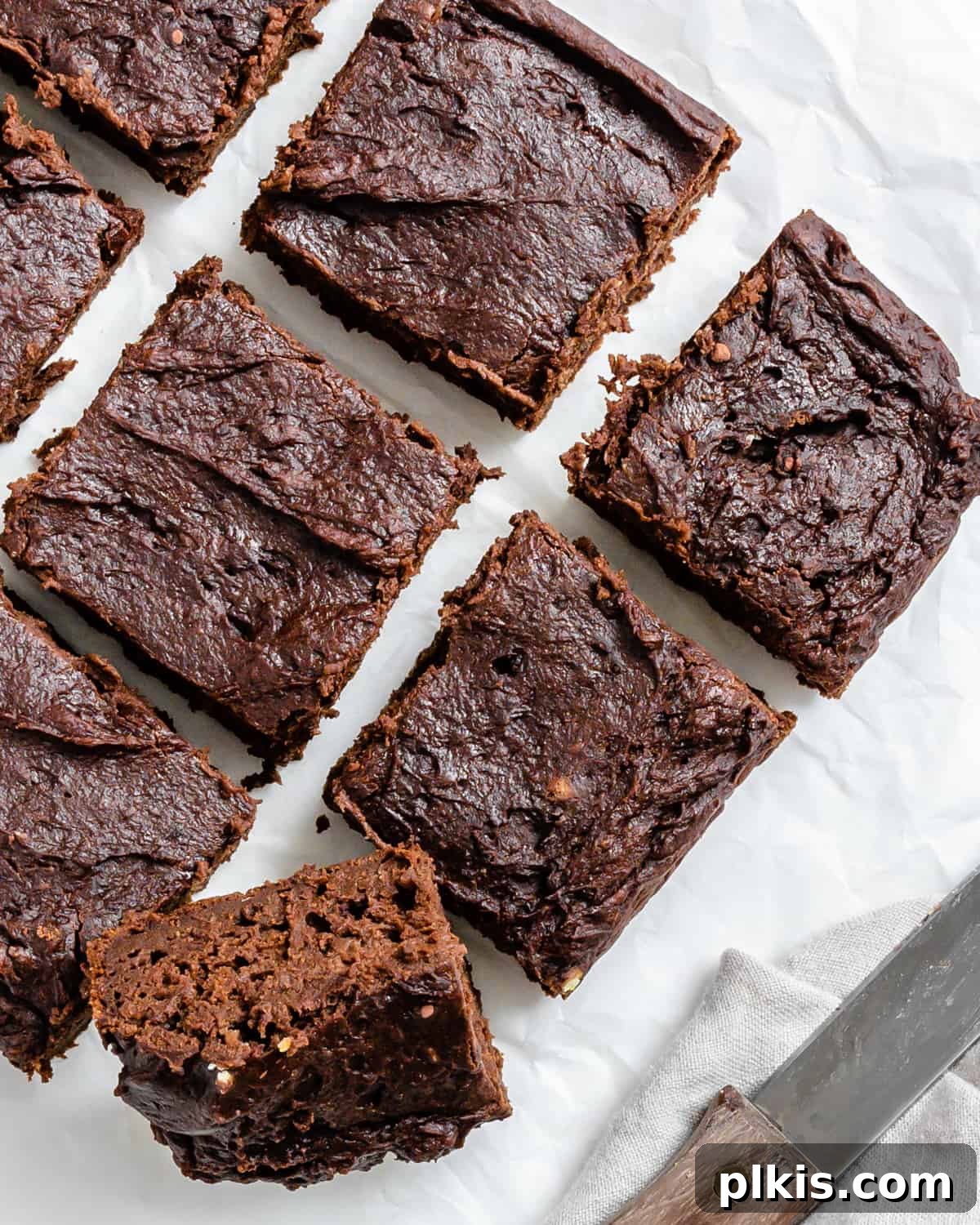 Pumpkin Spice Brownie Perfection 8 completed Easy Pumpkin Brownies on a white surface, with a bite taken from one