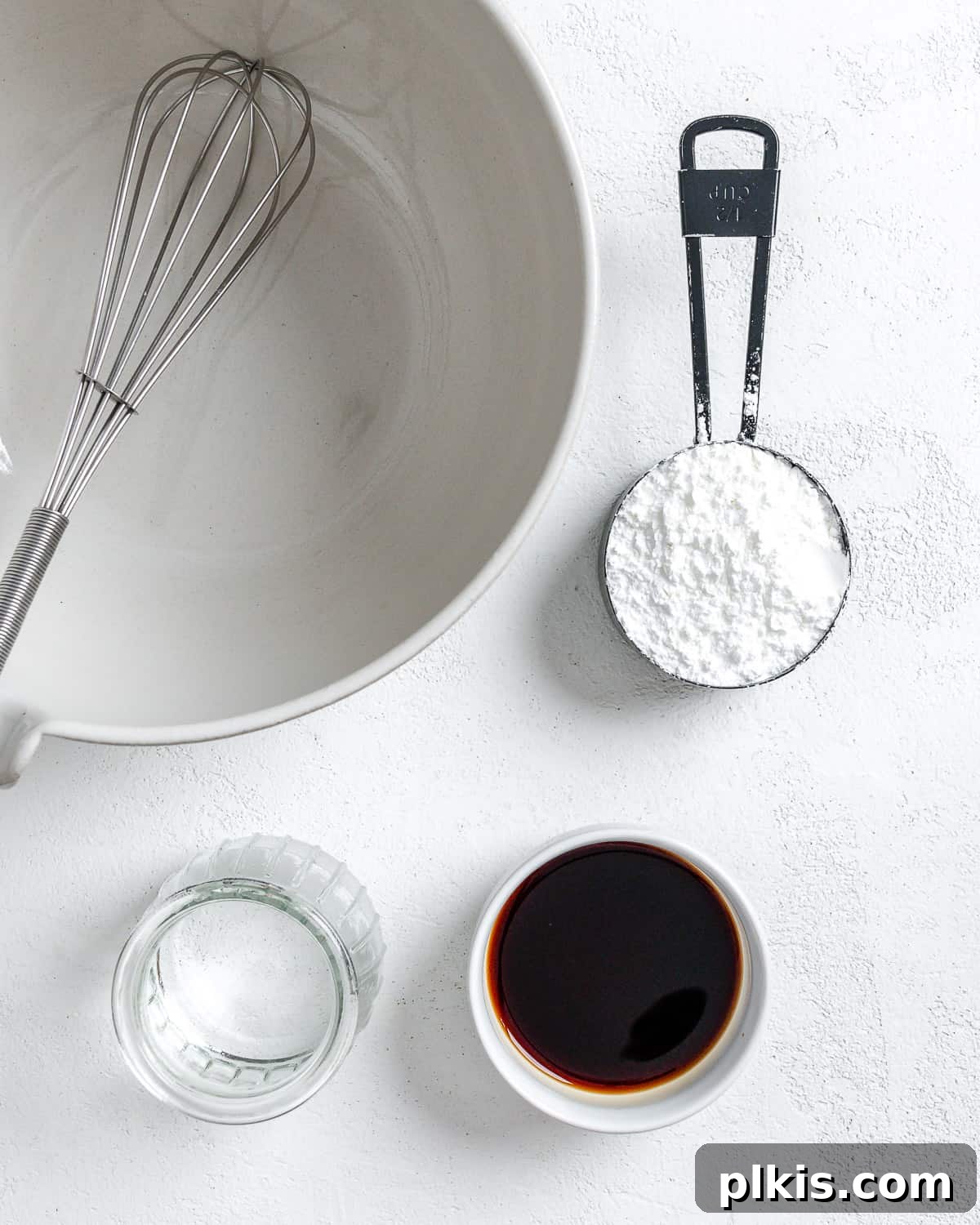 Ingredients for the cornstarch slurry (cornstarch, water, soy sauce) laid out next to a white bowl.