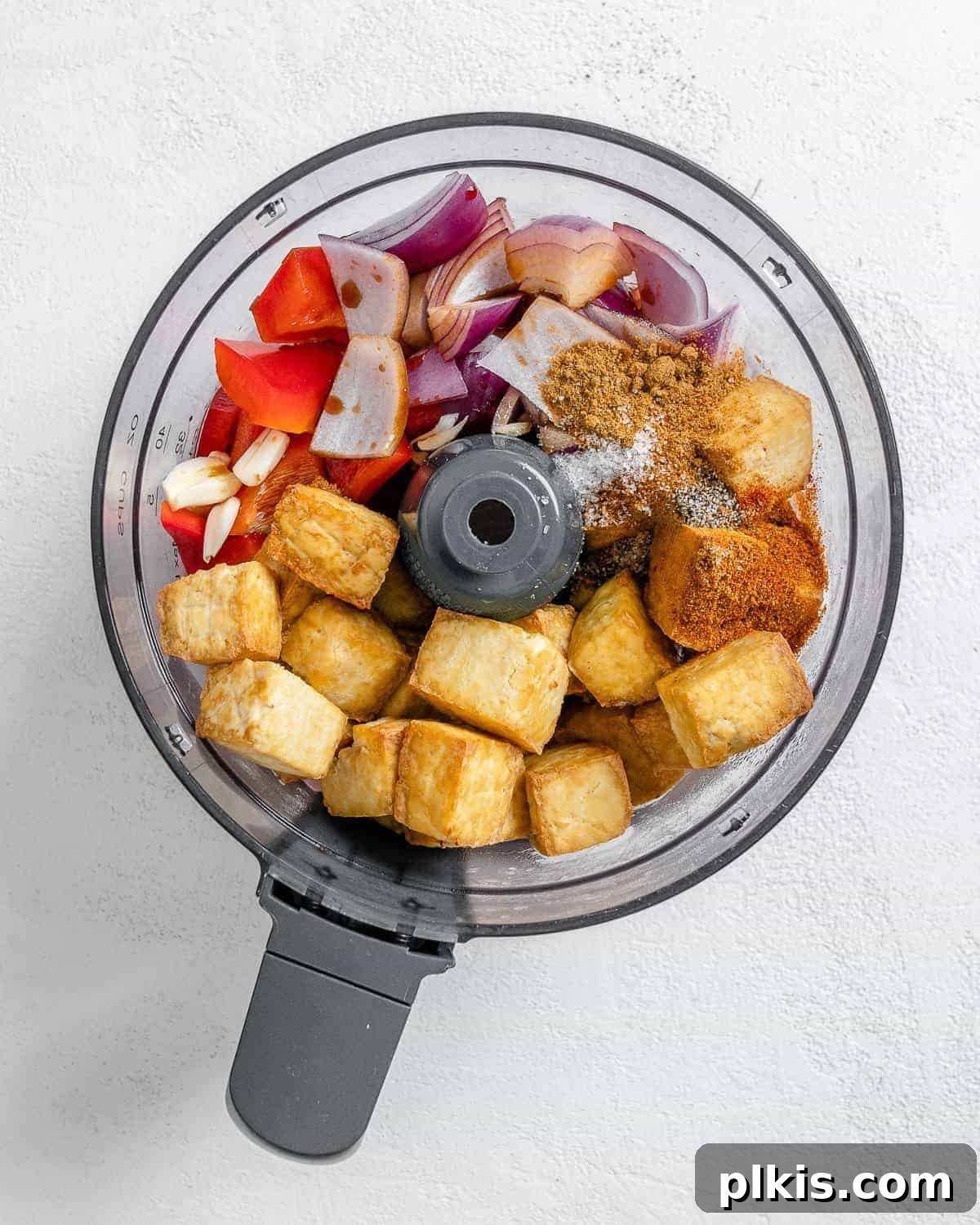 Zesty Tofu Tacos 6 Process shot of the tofu taco filling being prepared in a food processor, showing the initial crumbling of tofu and mixing with spices and vegetables.