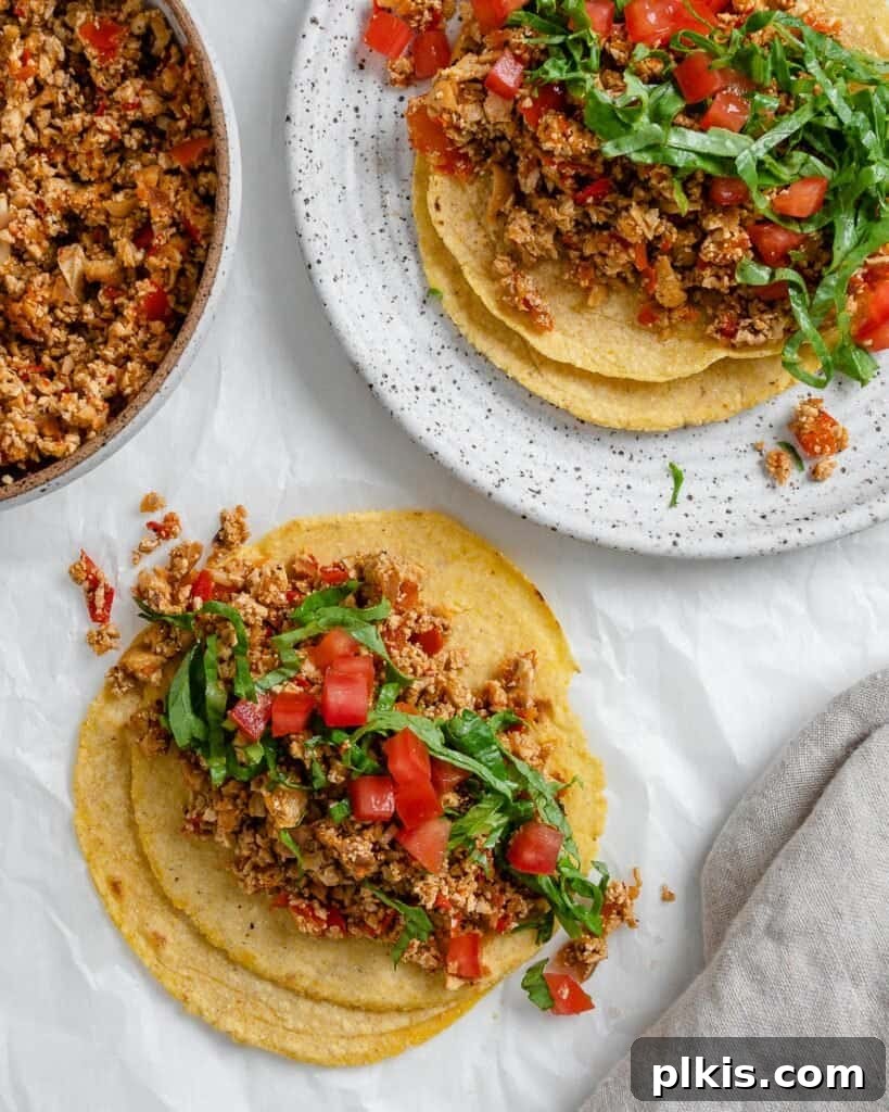 Zesty Tofu Tacos 9 Completed tofu tacos with a vibrant spread of toppings in the background, inviting a feast for plant-based food lovers.