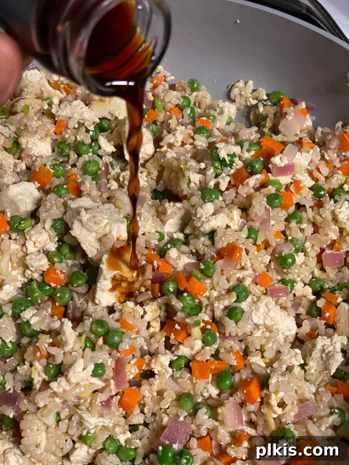 Quick Veggie Brown Rice Stir-Fry 7 process shot of adding soy sauce to pan
