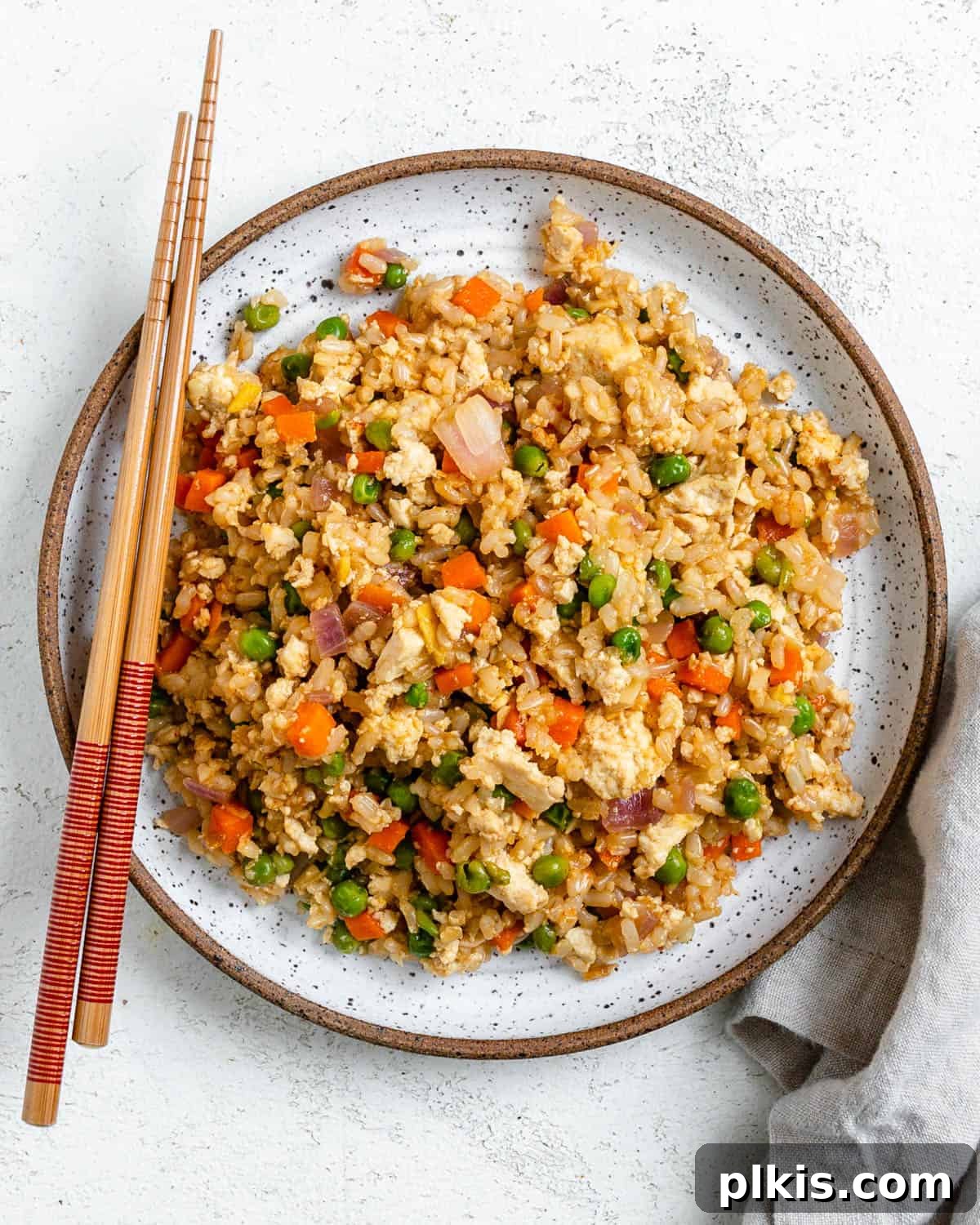 Quick Veggie Brown Rice Stir-Fry 8 completed Easy Vegetable Brown Fried Rice plated on a white plate against a light background alongside chopsticks