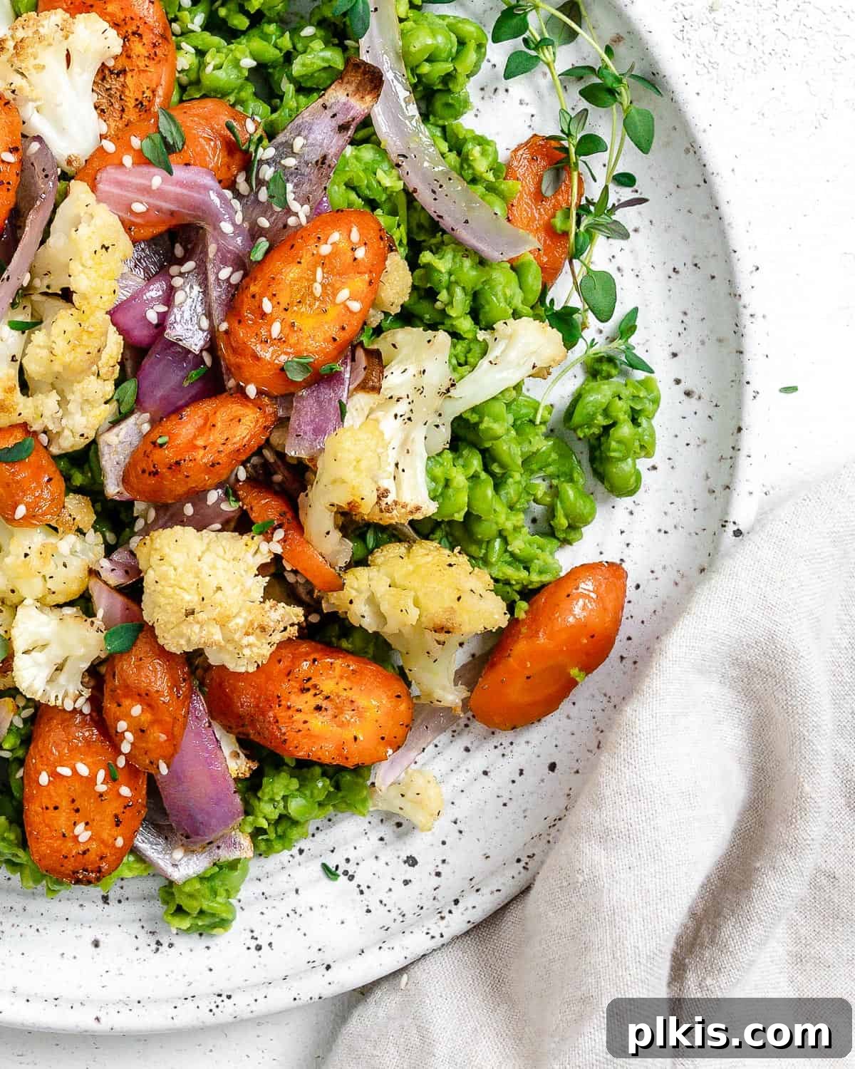 Effortless Creamy Peas with Golden Roasted Vegetables 11 completed Easy Mushy Peas with Roasted Veggies plated on a white bowl against a light background