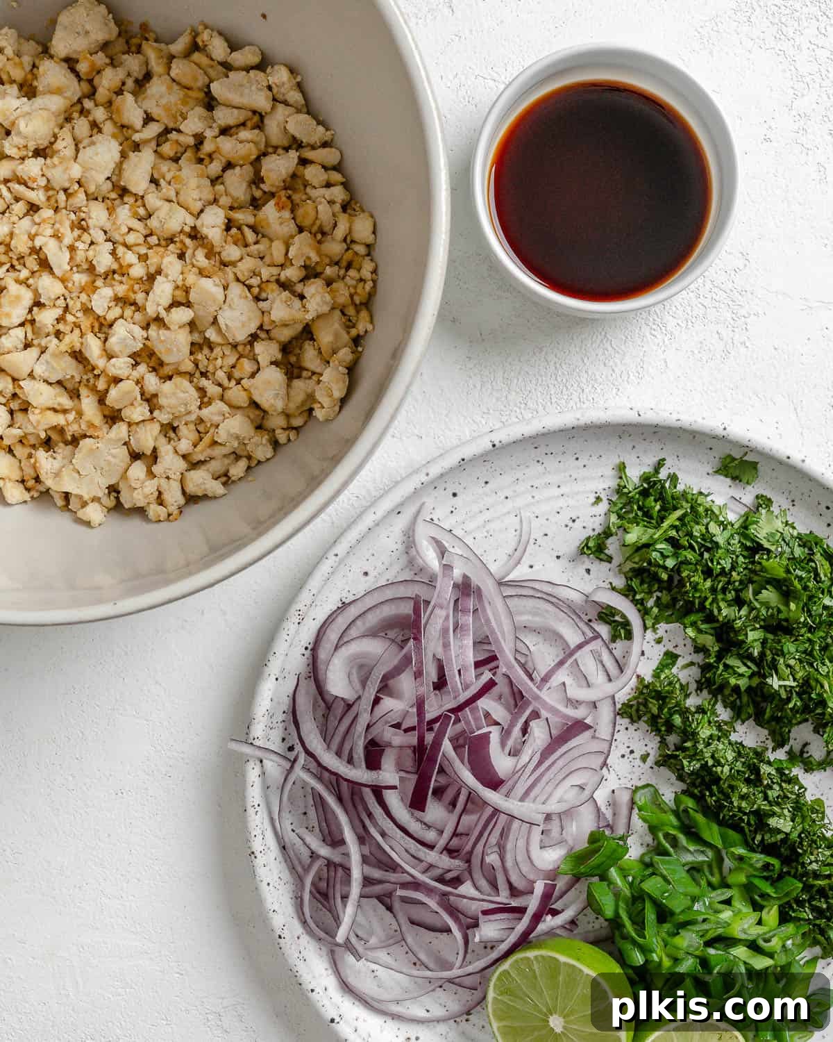 Vibrant Vegan Tofu Larb 5 Bowls of prepared larb ingredients next to a sauce, highlighting the freshness.