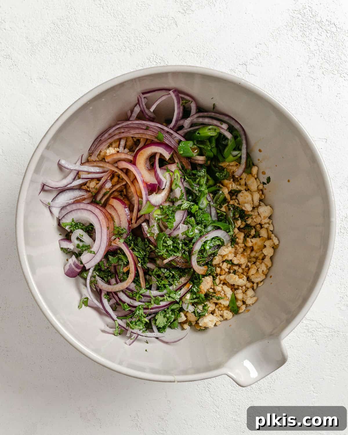 Vibrant Vegan Tofu Larb 6 Larb salad ingredients in a white bowl before mixing.