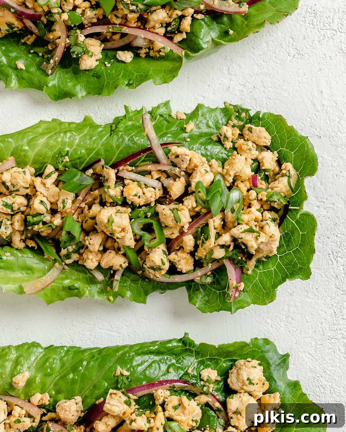 Vibrant Vegan Tofu Larb 8 Three completed larb salad servings arranged artfully against a white surface.