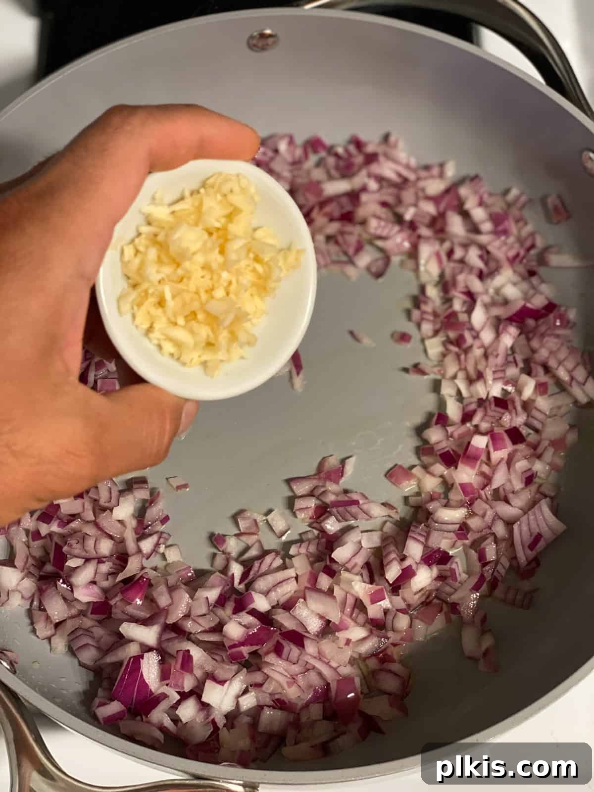 Deliciously Easy Vegan Sweet Potato Lasagna 5 process shot of adding garlic to pan