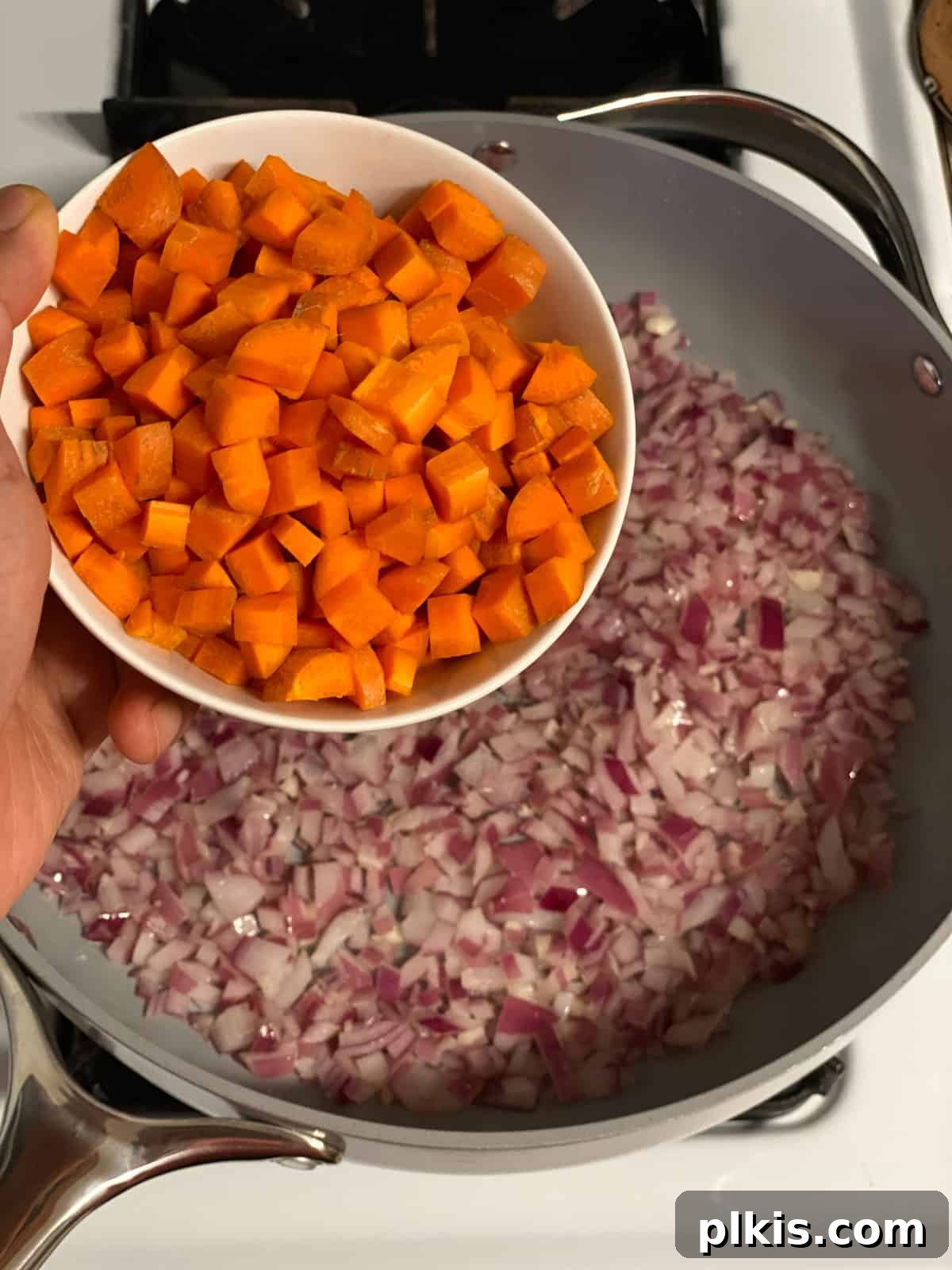 Deliciously Easy Vegan Sweet Potato Lasagna 6 process shot of adding carrots to pan