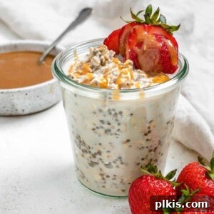 completed Salted Caramel Overnight Oats in a clear cup with ingredients against a white background