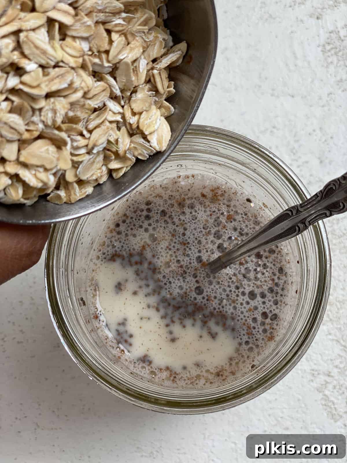 Decadent Salted Caramel Overnight Oats 6 process shot of adding oats to Salted Caramel Overnight Oats in a glass jar