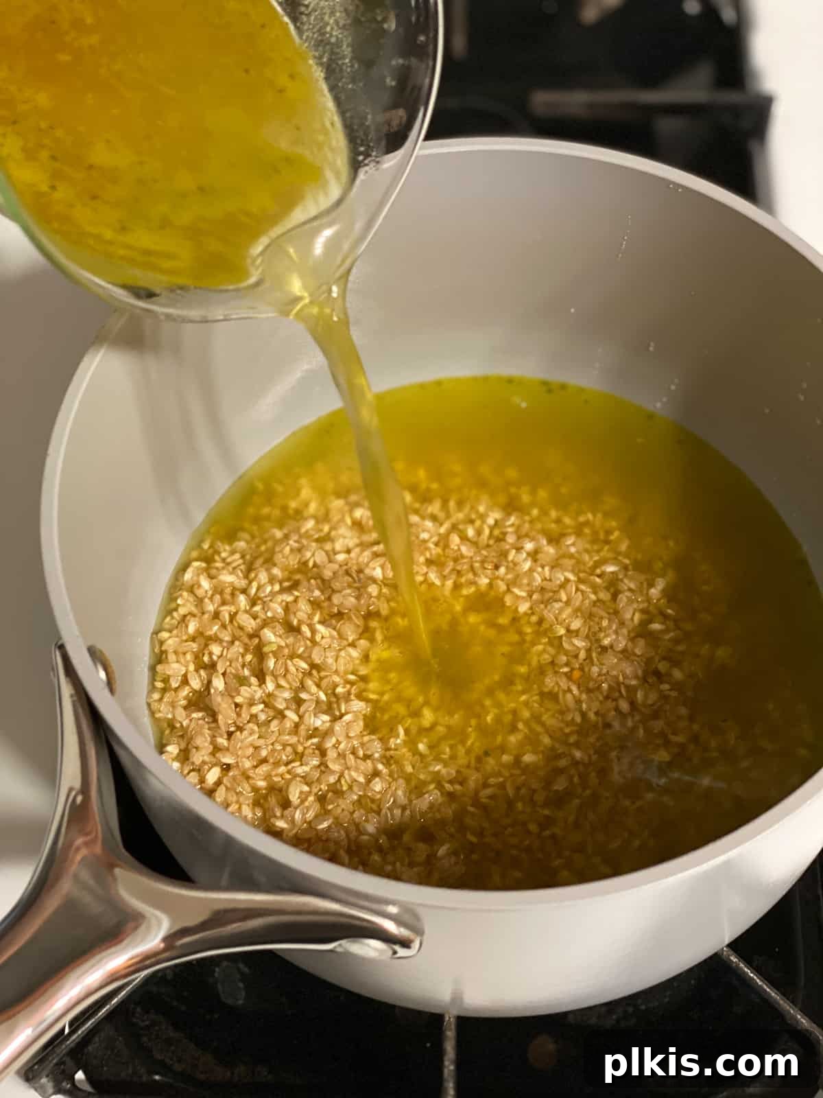 Vibrant Veggie Brown Rice Stir Fry 4 Close-up process shot showing vegetable broth being poured into a pot with brown rice, ready to be cooked.