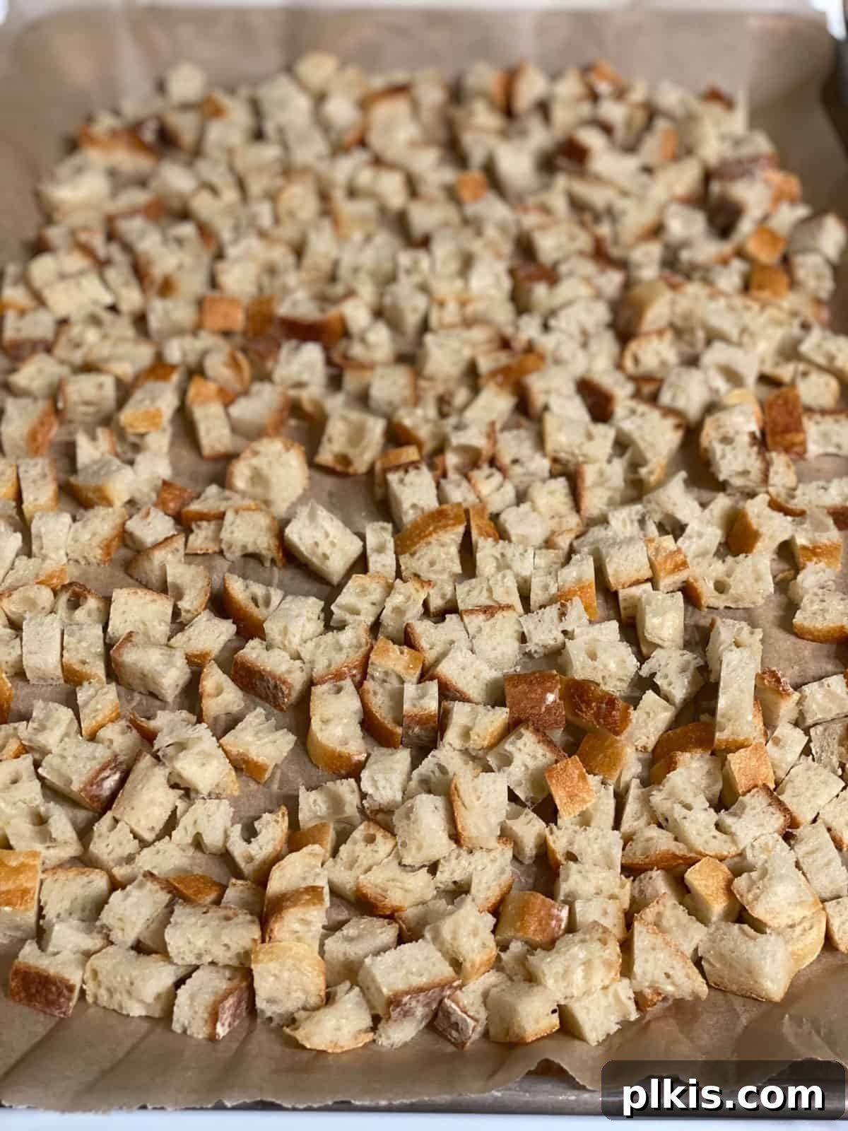 Ultimate Vegan Stuffing 4 Diced sourdough baguette pieces spread evenly on a large baking tray, ready to be dried out.